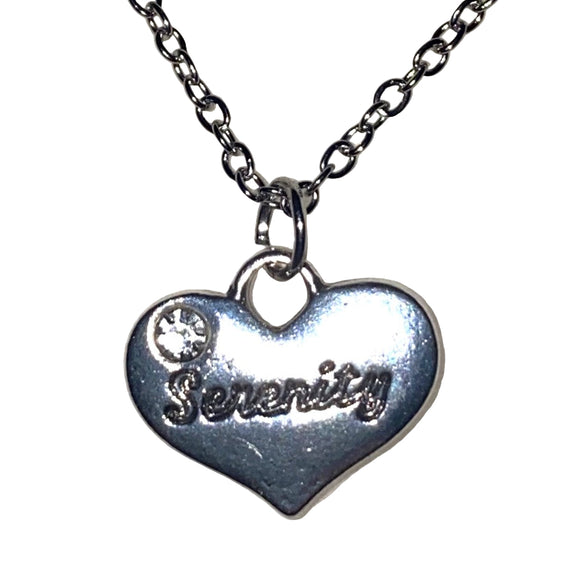 Silver heart-shaped pendant with 'Sevenity' engraving on a chain against a glittery white background