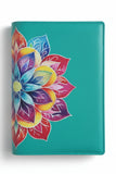 Turquoise notebook with a colorful floral design on a surface with green plants.