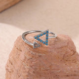 Silver ring with blue gemstones on a stone surface